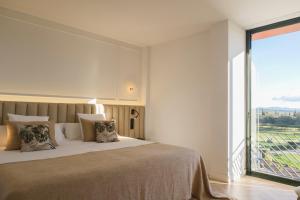 a bedroom with a large bed and a large window at Hotel TorreMirona Golf & Spa in Figueres