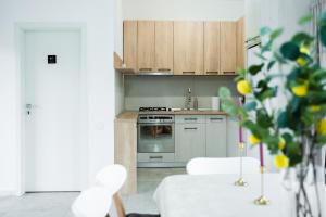 a kitchen with white appliances and a white table and chairs at Exclusive Villa Jacuzzi & BBQ in Şerbăneşti