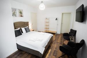 a bedroom with a bed and two chairs at Exclusive Villa Jacuzzi & BBQ in Şerbăneşti