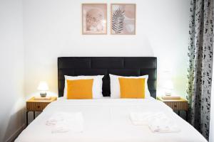 a bedroom with a large bed with orange and white pillows at Exclusive Villa Jacuzzi & BBQ in Şerbăneşti +27 photos
