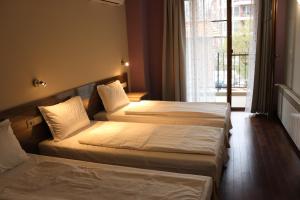 a hotel room with two beds and a window at Roots Hotel Old Town in Plovdiv