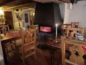 a living room with a fireplace and a table and a table and chairs at La Lobio in Molines-en-Queyras