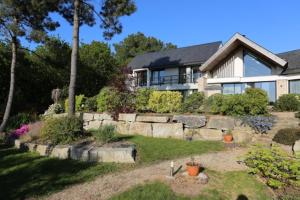 a house with a stone wall in front of a yard at Kerlenn in Baden