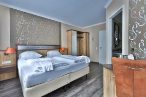 a bedroom with a large bed with white sheets at M13 Hotel in Riol