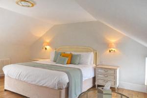 a bedroom with a bed with white sheets and orange pillows at The Dixcart Hotel in Sark