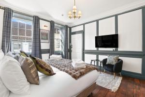 a bedroom with a large bed and a tv at The Library at The Merchants in Fenwick