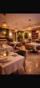 a restaurant with white tables and chairs and lights at Old Ridgeway Hotel in Chingford