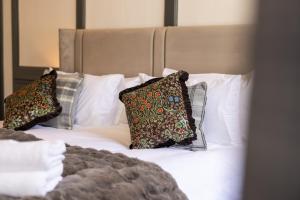 a bed with three pillows on top of it at The Library at The Merchants in Fenwick +26 photos