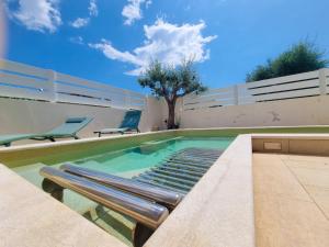 a swimming pool with two chairs and a tree at Calypso Luxury Pool&Spa in Pula