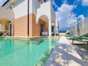 a swimming pool in front of a house at Calypso Luxury Pool&Spa in Pula
