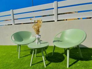 two green chairs and a vase on the grass at Calypso Luxury Pool&Spa in Pula