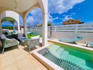 a patio with chairs and a swimming pool at Calypso Luxury Pool&Spa in Pula