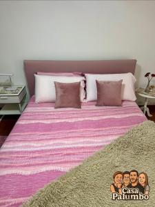 a large bed with a pink and purple blanket at Casa Palumbo in Bacoli