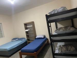 a room with two bunk beds with blue sheets at FIRMH HOSTEL CAFE DA MANHA incluso e traslado in Guarulhos