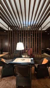 a room with a table and chairs and a lamp at Monochrome County 16th floor in Dehu Road +71 photos