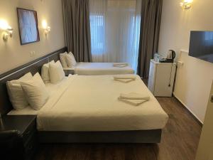 ein Hotelzimmer mit zwei Betten und einem Fernseher in der Unterkunft Hotel Balca in Izmir + 5 Fotos