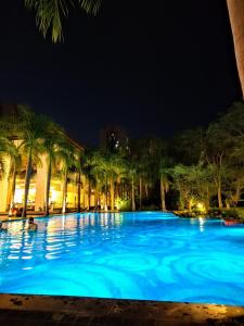 a large pool with blue water at night at Monochrome County 16th floor in Dehu Road