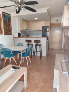 a kitchen and living room with a table and chairs at Apto 1 Hab, Terraza & Piscina, 5 min Playa in Playa de Gandia