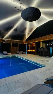 a large swimming pool in a building with a ceiling at Rodnei Retreat & Spa in Borşa