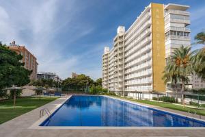 a swimming pool in front of a building at Playa Anaconda - Wellhome Alicante in Benimagrell