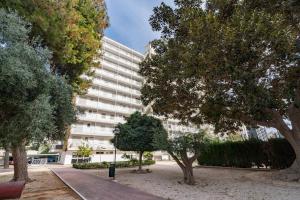 a large white building with trees in front of it at Playa Anaconda - Wellhome Alicante in Benimagrell