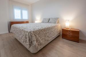 a bedroom with a bed and two lamps on a nightstand at Playa Anaconda - Wellhome Alicante in Benimagrell +36 photos