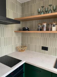 a kitchen with green cabinets and white tiles at ZIELONE DRZWI Hajnówka in Hajnówka +10 photos