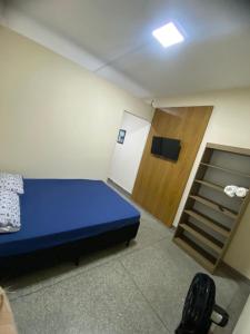 a small room with a blue bed and a closet at FIRMH HOSTEL CAFE DA MANHA incluso e traslado in Guarulhos