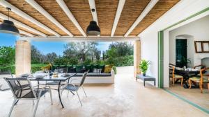 a patio with a table and chairs and a couch at The Ridge House with Sea View by Rentbeat in Carovigno