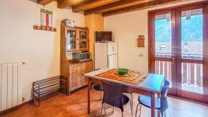 a kitchen with a table with chairs and a refrigerator at Casa Loca Colere in Colere