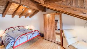 a bedroom with a bed and a wooden floor at Casa Loca Colere in Colere