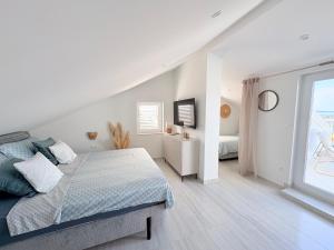 a white bedroom with a bed and a window at Villa TerraAurora in Barbat na Rabu +92 photos