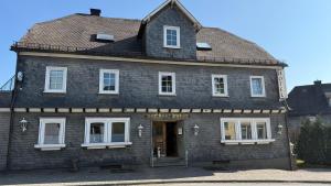 a large black building with a brown roof at Hotel Kaiser Friedrich in Bad Berleburg