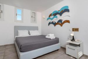 a bedroom with a bed in a white room at Maistros Village Santorini - Anamar Collection in Karterados +32 photos