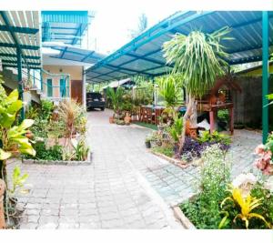 a patio with a bunch of plants in a building at บ้านอังกาบ Aungkab homestay in Ban Muang Len