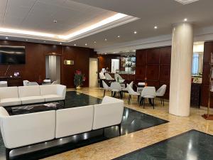a lobby with white chairs and tables and a bar at As Hotel Dei Giovi in Cesano Maderno