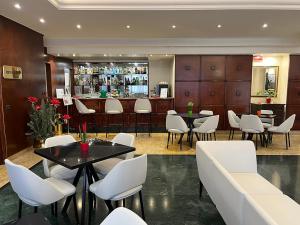a restaurant with white chairs and tables and a bar at As Hotel Dei Giovi in Cesano Maderno