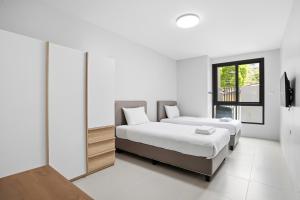 a bedroom with two beds and a window at Tiva Residence Bangkok in Bangkok
