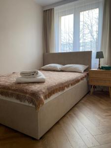 a large bed in a bedroom with a window at ZIELONE DRZWI Hajnówka in Hajnówka