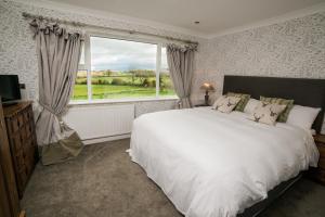 a bedroom with a large white bed and a window at Stirk House Hotel in Clitheroe +113 photos