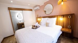 a bedroom with a large white bed with a mirror at Maison le patio in Saint-Denis