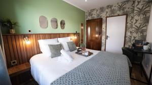 a bedroom with a large bed with white sheets and pillows at Maison le patio in Saint-Denis