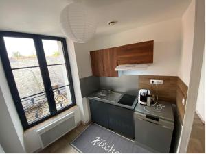 a small kitchen with a stove and a window at chez Alain et Sylvie in Braine