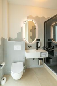 a bathroom with a toilet and a sink and a mirror at Midi Inn Parkhotel Mitte in Berlin