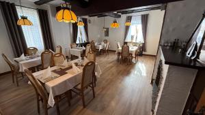 a dining room with tables and chairs and windows at Hotel Kaiser Friedrich in Bad Berleburg