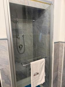a shower with a white towel on a towel rack at Affittacamere Casa Delle Rose in Antria