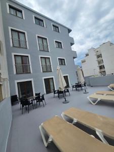 a building with tables and umbrellas on a patio at Das Hostal in El Arenal