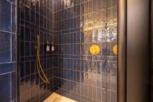 a bathroom with a shower with blue tiles at CP Apartments San Mamés in Bilbao