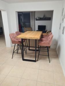 a wooden table and two pink chairs in a room at Apartman Collie in Silŭvky