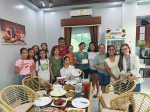 a group of people standing around a table with food at Yurich Hotel in Romblon